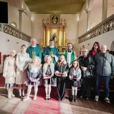 Ojciec Ezawa i Jakuba z rodziną w kościele. Dzieci odbierają nagrody.