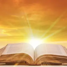 Otwarta Biblia, z której wydobywa się światło, niczym niesamowite cytaty z biblii rozświetlające niebo.