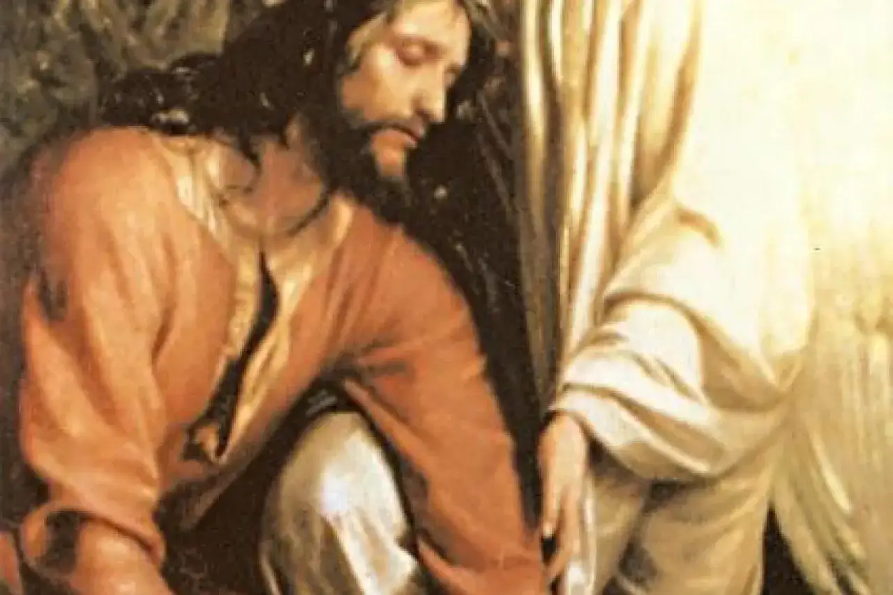 Jezus w Ogrójcu, klęczący w modlitwie, z głową pochyloną w smutku. Obok niego anioł podtrzymuje go.