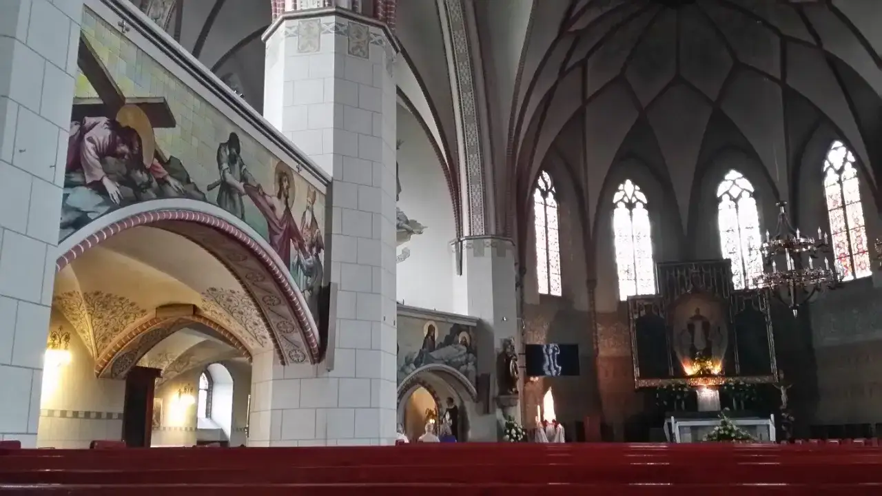 Wnętrze katedry w Legnicy, gdzie można dostrzec malowidła nawiązujące do Męki Pańskiej i ołtarz. To miejsce, gdzie wierni doświadczają cudu eucharystycznego w Legnicy.