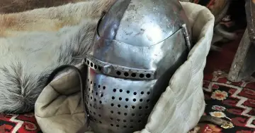 Zbroja templariuszy w Polsce. Metalowy hełm z otworami, otoczony futrem i tkaniną, sugeruje historyczne artefakty.