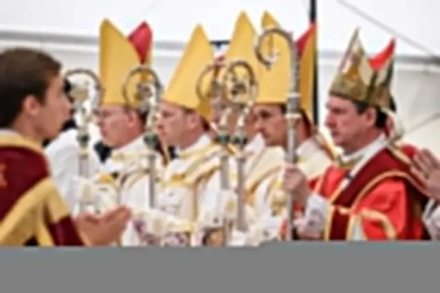 Biskupi w pontyfikalnych strojach, z pastorałami, w oczekiwaniu na uroczystość, która może być związana z klątwą kościelną.